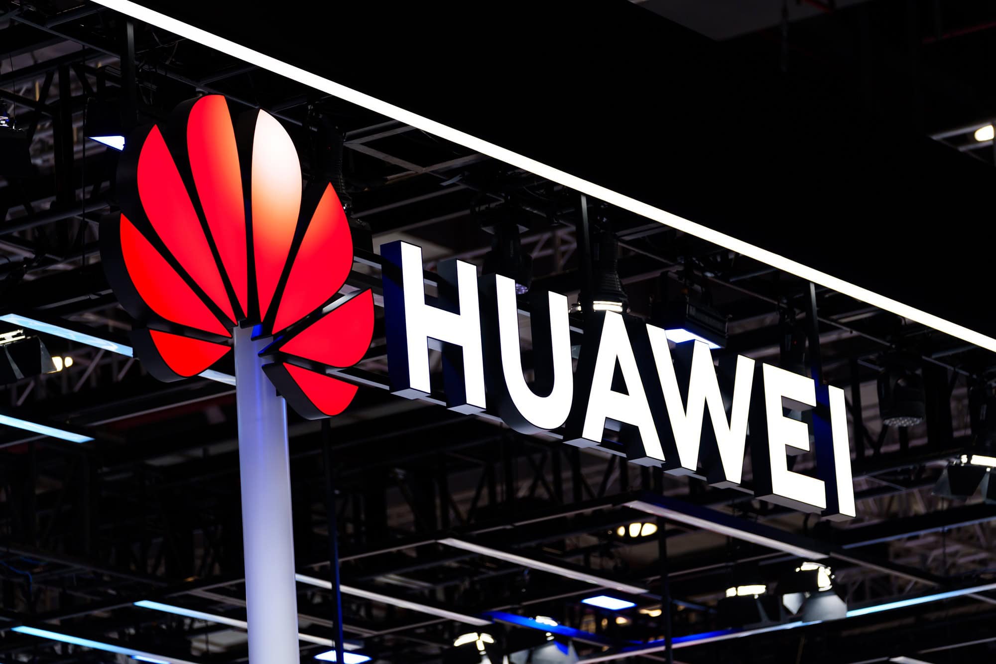 Logo da Huawei exibido em estande da empresa durante evento de tecnologia