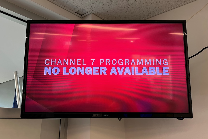 A TV high on a wall with a red graphic saying CHANNEL 7 PROGRAMMING NO LONGER AVAILABLE