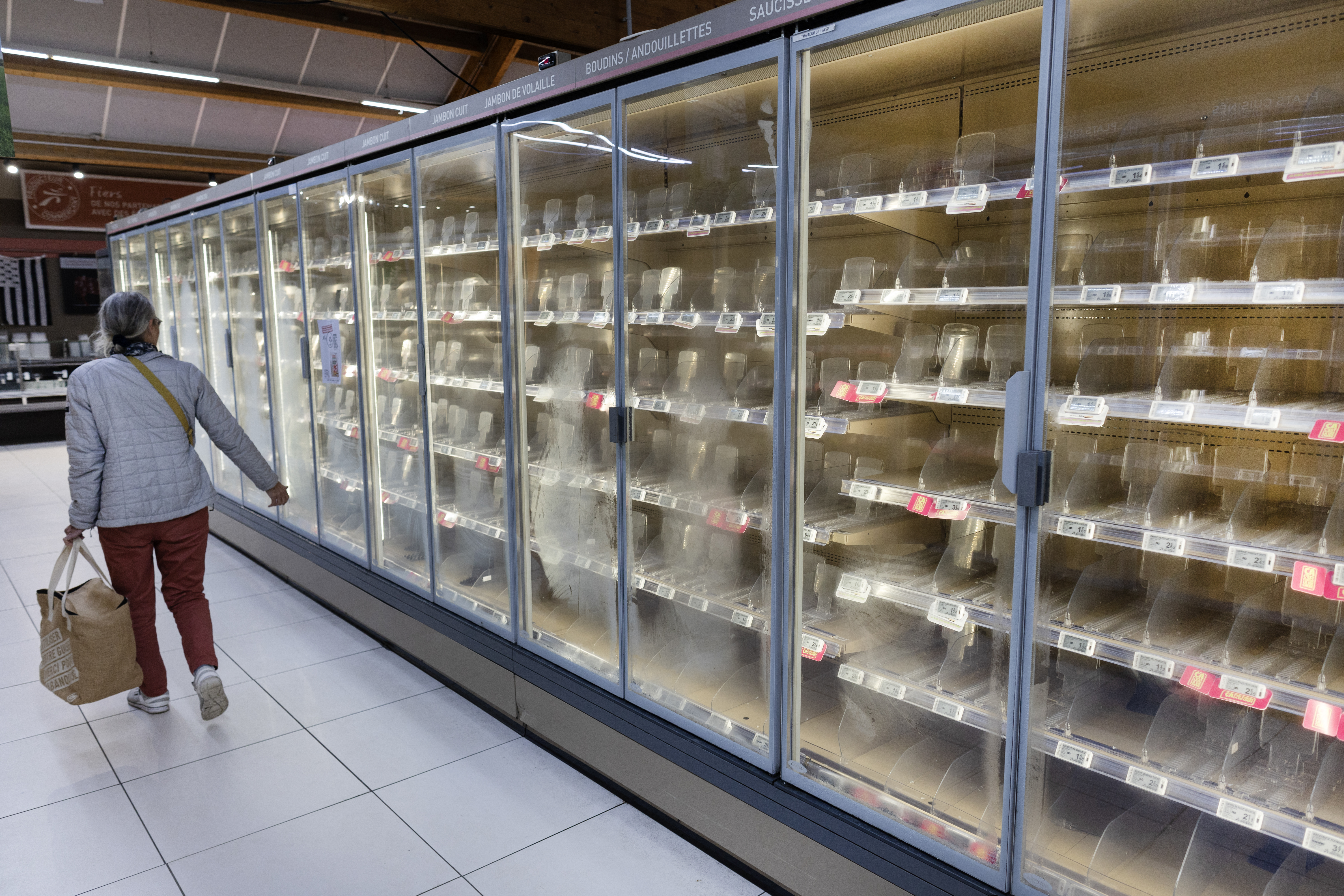 A woman walks past empty fresh-food refrigerators at an Intermarché supermarket in Névez, western France, on October 12, 2026, following a cyberattack affecting the French supermarket chains Intermarché and Cooperative U that caused their refrigerators to defrost. Some 150 to 200 Intermarché stores were targeted in the attack on October 12, 2026, along with nearly 100 Coopérative U outlets, the retailers said. BFM TV reported that rival giant E. Leclerc was also affected, with hackers "managing