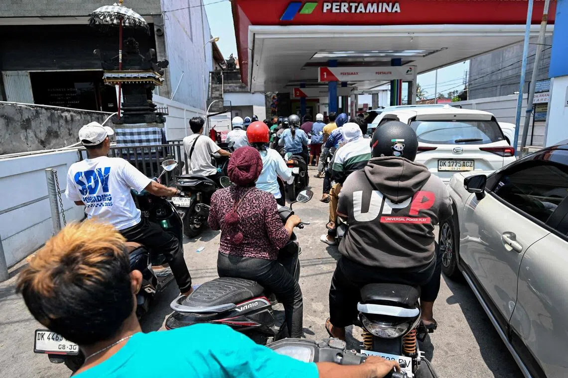 Motorcyclists queue to refuel at a gas station in Denpasar amid a fuel supply shortage on Indonesia’s resort island of Bali on Oct 14.