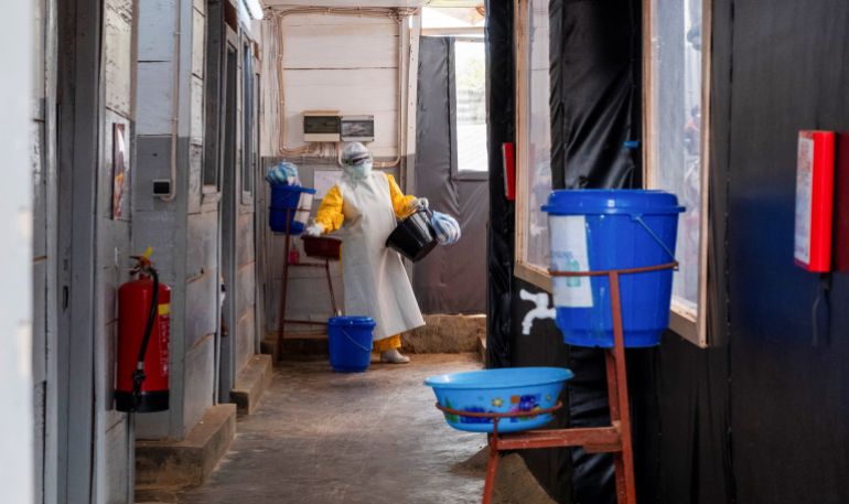 A worker in protective gear handles sanitary basins at an Ebola treatment centre run by Médecins Sans Frontières in Butembo, eastern DRC [Gradel Muyisa Mumbere/Reuters]